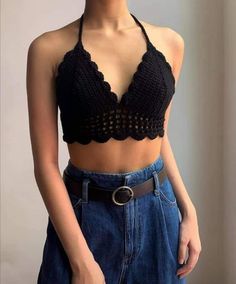 a woman wearing a black crop top and jeans