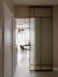 an open door leading to a dining room with a table and chairs in the background