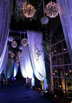 an outdoor event with hanging disco balls and drapes