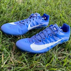 a pair of blue and white nike shoes on the grass