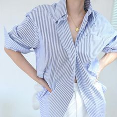 The Oversized Pinstripe Button Down Shirt Exudes Effortless Style With Its Loose Fit And Bold Pinstripe Pattern. The Elongated Silhouette Offers A Contemporary Edge, Making It A Versatile Piece That Seamlessly Transitions From Casual To Smart-Casual Occasions. Pair It With Tailored Trousers For A Polished Look Or With Denim For A Laid-Back, On-Trend Vibe. The Oversized Fit Adds A Relaxed And Comfortable Feel, While The Pinstripes Elevate The Shirt's Sophistication, Making It A Modern Wardrobe St Oversized Summer Shirt With Striped Collar, Striped Oversized Button-up Blouse, Oversized Striped Button-up Blouse, Oversized Striped Shirt With Button Closure, Vertical Stripes Button-up Shirt For Day Out, Oversized Button-up Blouse With Vertical Stripes, Trendy Oversized Striped Blouse, Oversized Striped Tops With Buttons, Striped Shirts