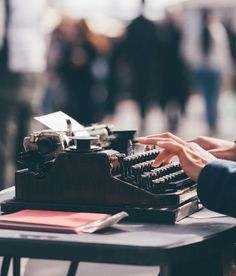 a person typing on an old fashioned typewriter