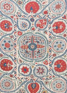 an intricately designed rug with red, blue and white designs on the front side