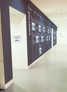 an empty hallway with a large poster on the wall that says it's time