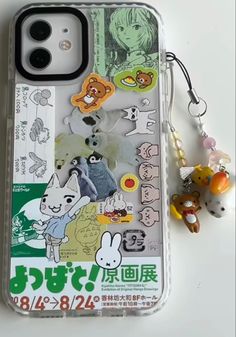 an iphone case with various stickers on it and a keychain attached to the back