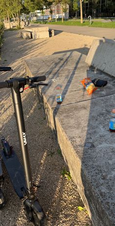 the scooter is parked on the side of the road near some trash cans