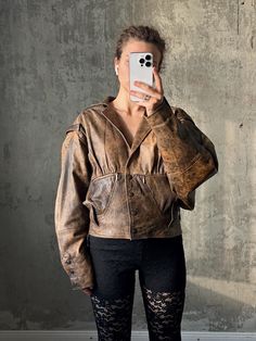 Vintage 80s distressed leather bomber jacket in brown, 100% genuine leather, polyester lining, It has a worn-in appearance, with visible creases and a matt finish. Fits S-L, narrower on the hips zone, the jacket features a structure design low pointed collar, front button closure, and slightly oversized sleeves, giving it a rugged, grungy and edgy look. Overall good vintage condition. Measurements: Shoulders - 60cm / 23.6" Sleeve - 63cm / 24.8" Length - 75cm / 29.5" Bust from armpit to armpit - Vintage Brown Biker Jacket For Streetwear, Brown Post-apocalyptic Outerwear For Fall, Distressed Brown Leather Jacket With Long Sleeves, Brown Distressed Leather Jacket With Long Sleeves, Vintage Distressed Leather Jacket For Streetwear, Vintage Brown Distressed Biker Jacket, Vintage Brown Leather Jacket For Streetwear, Vintage Brown Distressed Outerwear, Vintage Distressed Brown Outerwear