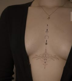 a woman's chest with an arrow tattoo on it