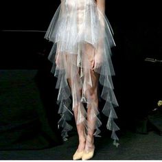 a woman in a white dress and veil on the runway