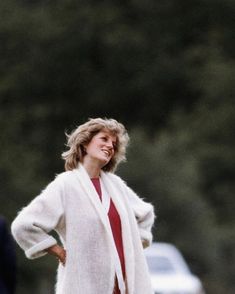 a woman wearing a white coat and red dress