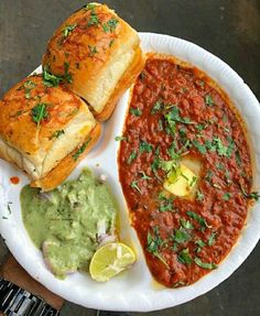 a white plate topped with two sandwiches and guacamole