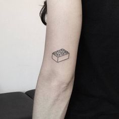 a person with a lego tattoo on their arm