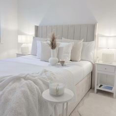 a bed with white sheets and pillows in a bedroom