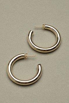 Oversized hoops, handmade from recycled brass and plated in 14K gold. Hypoallergenic posts with engraved butterfly backings. Jewelry Care: The oils from your skin transfer to the metal and need to be washed off periodically. The easiest way to clean your earrings is to wash with mild soap and wipe with soft, dry cloth. Store when not in use. Handmade from recycled brass 14K Gold Plated Hypoallergenic posts and logo-engraved backings Approximately 2" inches in diameter 5.2mm thick Nickel-free Classic Brass Hoop Earrings, Gold Tarnish-resistant Rounded Earrings, Gold Polished Finish Earrings, Everyday Gold Recycled Gold Earrings, Gold Rounded Earrings With Polished Finish, Tarnish Resistant Hoop Earrings In Recycled Gold, Tarnish Resistant Recycled Gold Hoop Earrings, Everyday Brass Earrings With Polished Finish, Classic Gold Hoop Earrings In Recycled Gold