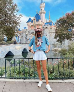 a woman standing in front of a castle