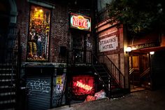 an alleyway at night with neon signs and graffiti