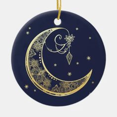 a round ornament with a crescent and stars on the bottom, hanging from a cord