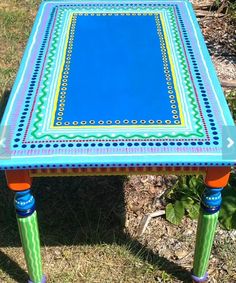 a blue and green table sitting in the grass