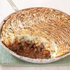 a pie dish with meat and potatoes in it