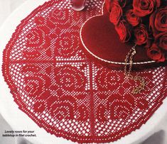 a table with red roses on it and a heart shaped doily in the center