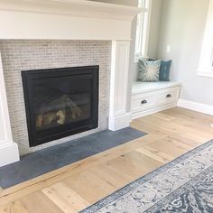 a living room with a fire place in the center and a rug on the floor