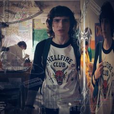 two young men standing in front of a mirror wearing t - shirts with the words hellfire club on them