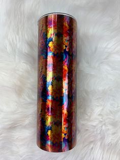 a colorful vase sitting on top of a white fur covered floor