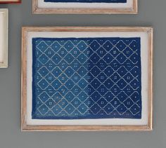 three framed pictures hang on the wall next to each other, one with a blue and white pattern