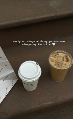 a cup of coffee sitting on top of a set of steps next to a paper