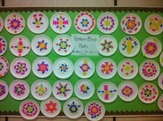 paper plates with colorful designs on them are arranged in a pattern for the children's table