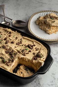 there is a cake in the pan with frosting and chocolate toppings on it