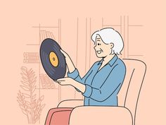 an older woman sitting in a chair holding up a record that is being held by her hand