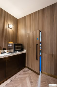 a kitchen with wood paneling and a microwave on top of the counter next to it