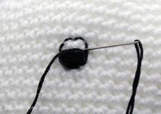 the crochet hook has been hooked up to an object that is white and black