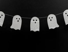 paper ghost buntings are hanging from a string on a black background with words written in white