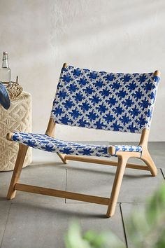 a blue and white chair sitting on top of a tile floor next to a bottle