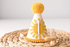 a yellow and white birthday hat on top of a woven basket