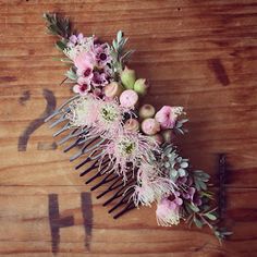 a comb with flowers on it sitting on top of a wooden table