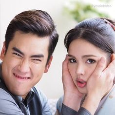 a man and woman posing for the camera with their hands on their face, smiling