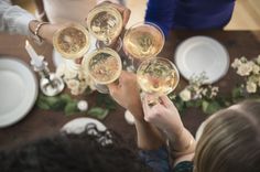 several people toasting with wine glasses on a table