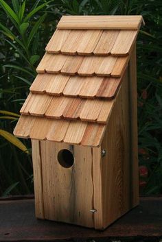 a wooden birdhouse with a roof made out of wood