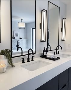 a bathroom with double sinks and large mirrors on the wall above them is lit by candles