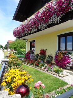 a house with lots of flowers growing on the roof