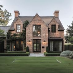 a large brick house surrounded by lush green grass