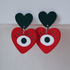 'Heart Eyes Red Velvet' Red, Silver and Black Earrings Turn that frown upside down with some eclectic and ornate pieces reminiscent of fortune telling and classic American neo-traditional tattoo imagery. Soft suede-like red hearts with wide eyes form the dangling charm portions of this set of punchy earrings, contrasting the matte black heart charms on the studs. A corresponding suede-feel choker is available as shown in these images. Carefully crafted and lovingly handmade on the Scottish coast Quirky Red Jewelry For Gifts, Red Heart-shaped Hand Painted Jewelry, Hand-painted Red Jewelry For Valentine's Day, Hand Painted Red Jewelry For Valentine's Day, Handmade Artsy Red Jewelry, Artsy Handmade Red Jewelry, Punchy Earrings, Velvet Earrings, Scottish Coast