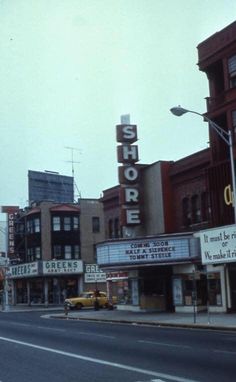 an old photo of a street corner with stores