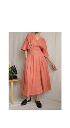 Details Linen faux-wrap dress with basque waist (semi-elasticated), pleated detailing at the front, and seam pockets. No lining. Midi-length. Slips on with a concealed snap button closure at chest. Made-to-order. Ships in 15-18 days.  Color/Couleur: Salmon Pink  Material:100% linen (wrinkle-prone)  Size/Taille:Made-to-measure. Please provide bust/waist/hips size and height during checkout.Note that bust and hips are both measured at the widest/fullest point whereas the waist is measured at the s Salmon Dress, Basque Waist, Wrap Midi Dress, Summer Linen, Salmon Pink, Faux Wrap Dress, Dress Summer, Dress Clothes For Women, Snap Button