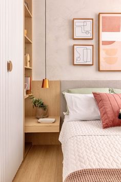 a bedroom with a bed, nightstand and pictures on the wall