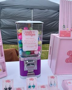 there is a candy dispenser on the table next to other jewelry items