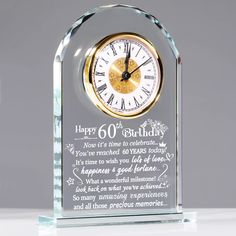 a clear glass clock with the words happy 60th birthday written on it